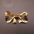 Kraftig sløjfebroche udført af 14 karat guld 