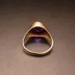 Guldring af otte karat prydet med varm mørklilla sten
