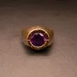 Guldring af otte karat prydet med varm mørklilla sten
