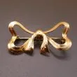 Kraftig sløjfebroche udført af 14 karat guld 