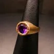 Guldring af otte karat prydet med varm mørklilla sten