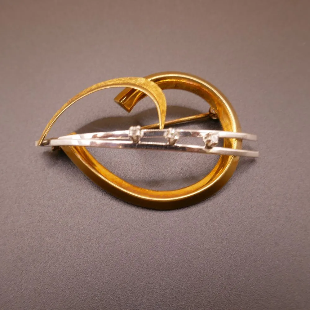 Broche udført i hvid- samt gult guld, prydet med 3 brillanter
