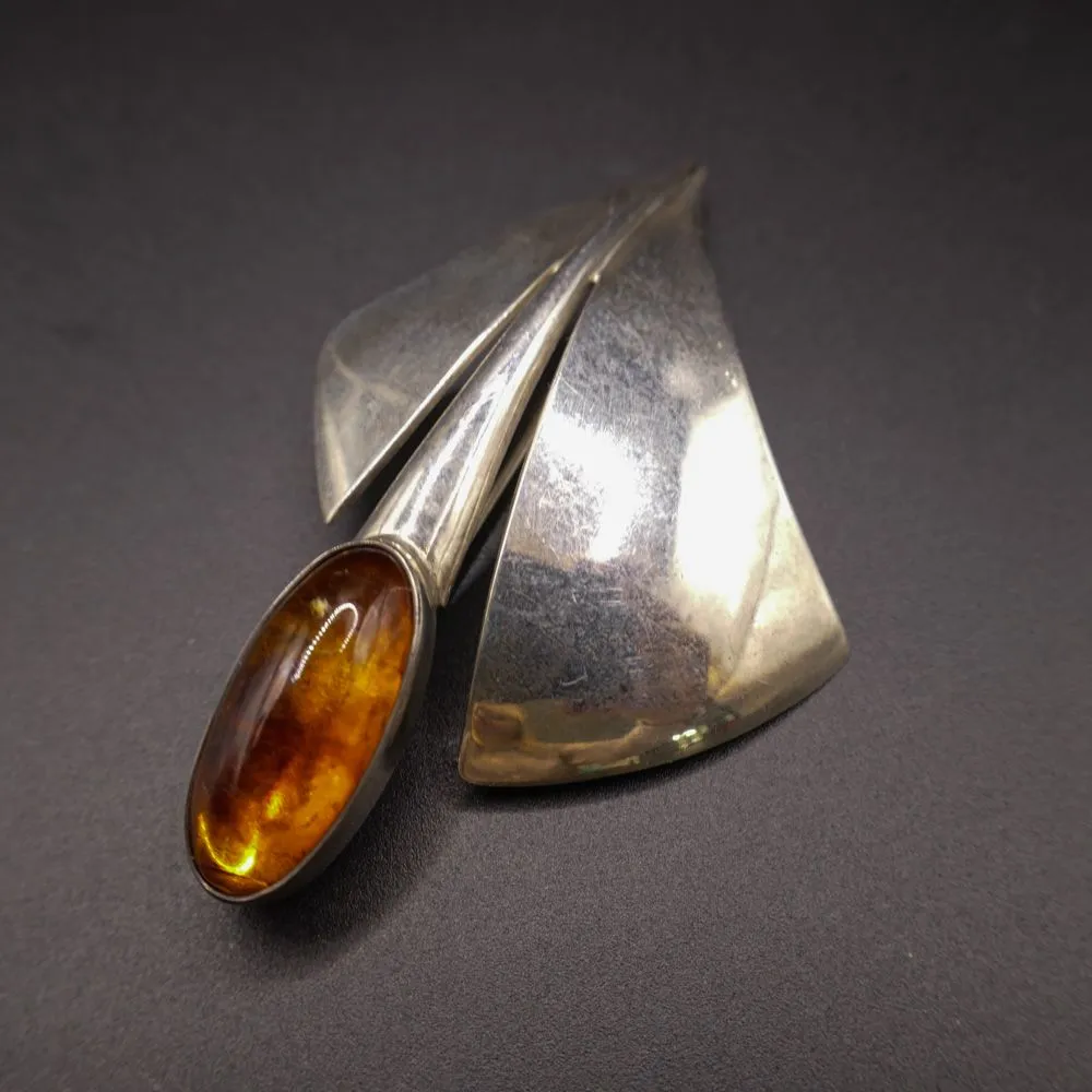 Stiliseret sølvbroche prydet med rav fra N.E. From. 